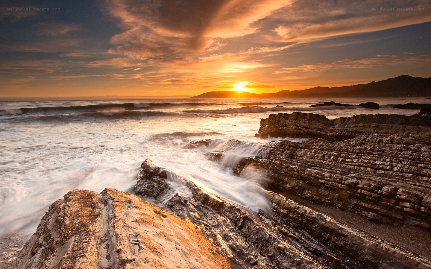 Sunset over rocky coastline
