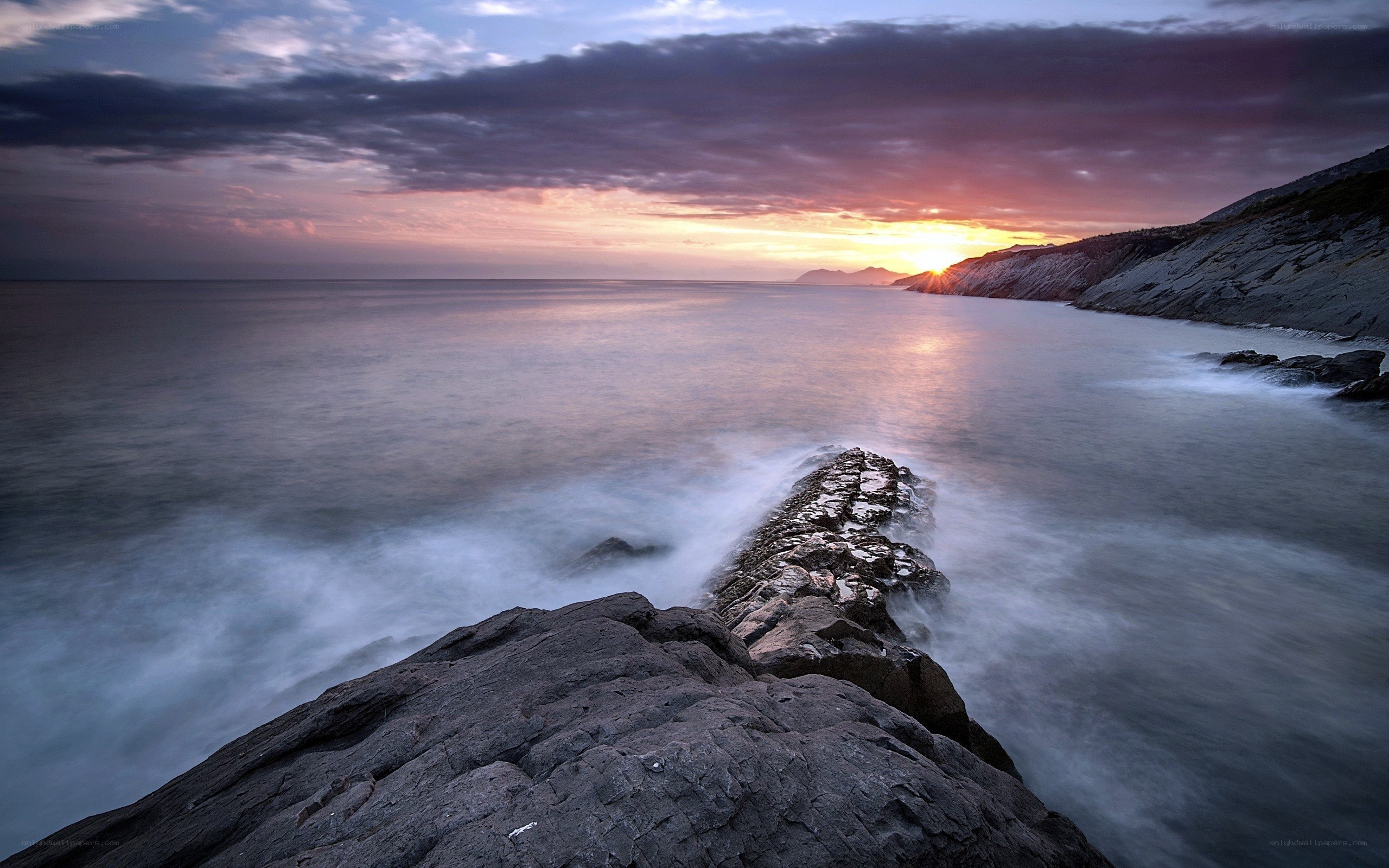 Sunset over rocky coastline