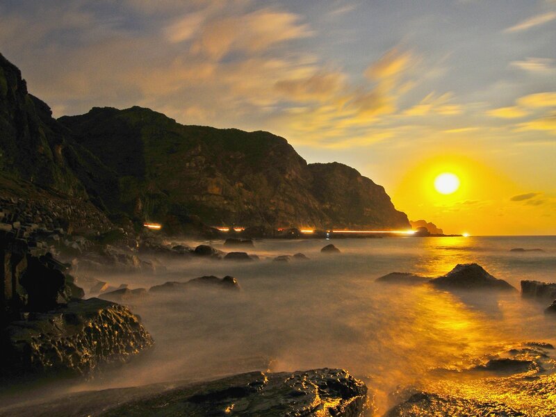 Sunset over rocky coastline