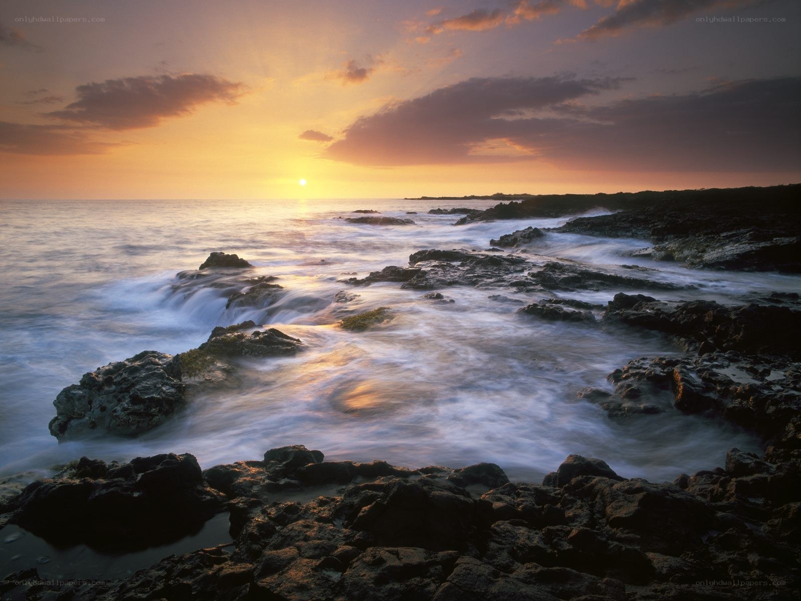 Sunset over rocky coastline