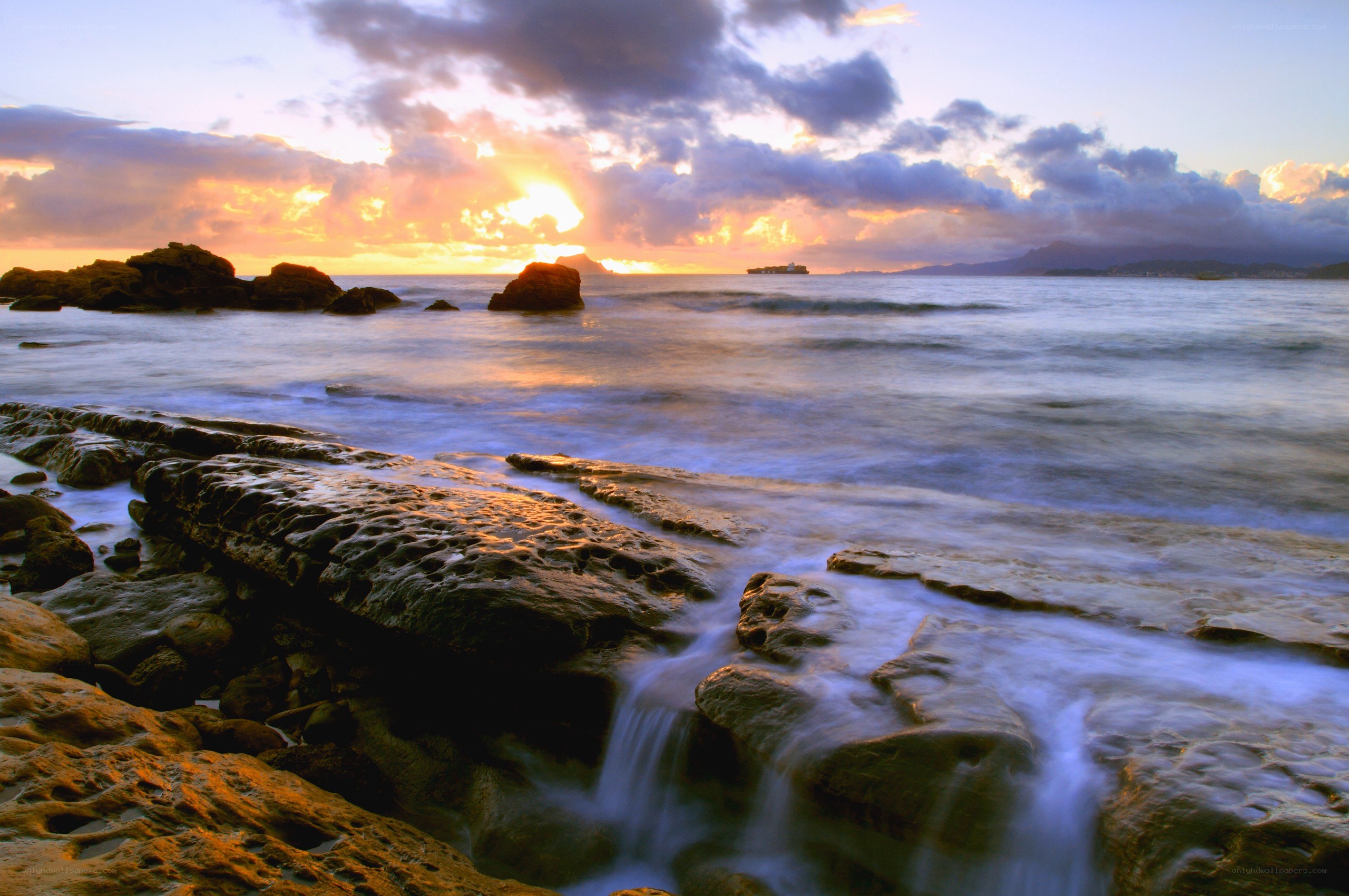 Sunset over rocky coastline
