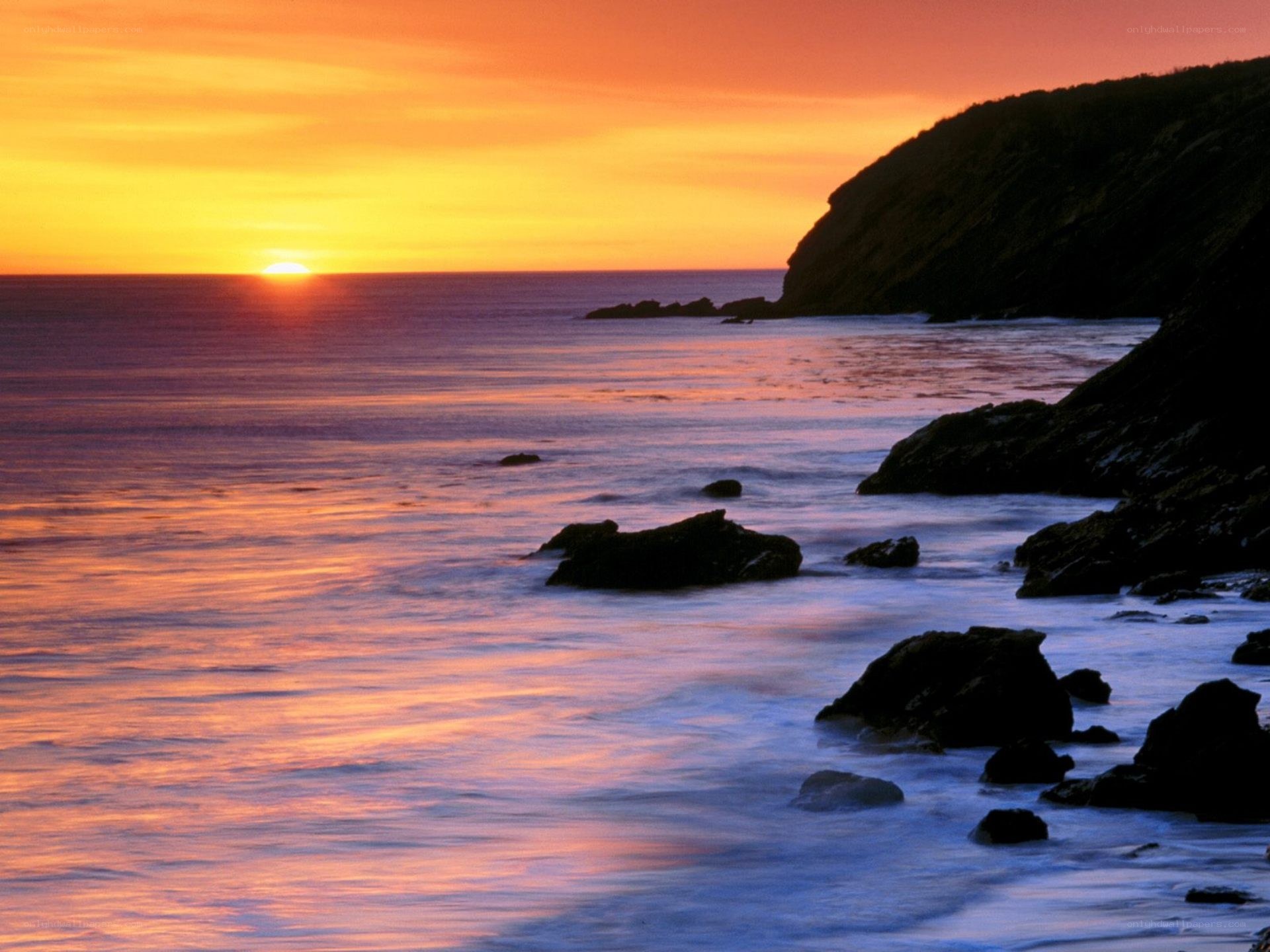Sunset over rocky coastline