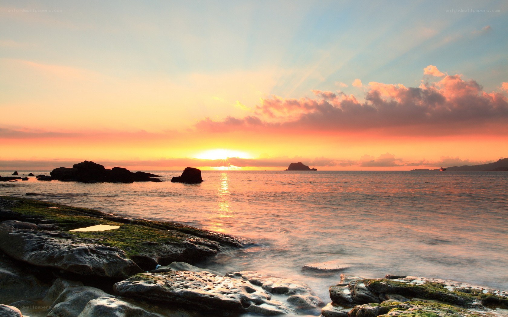 sunset over rocky coastline