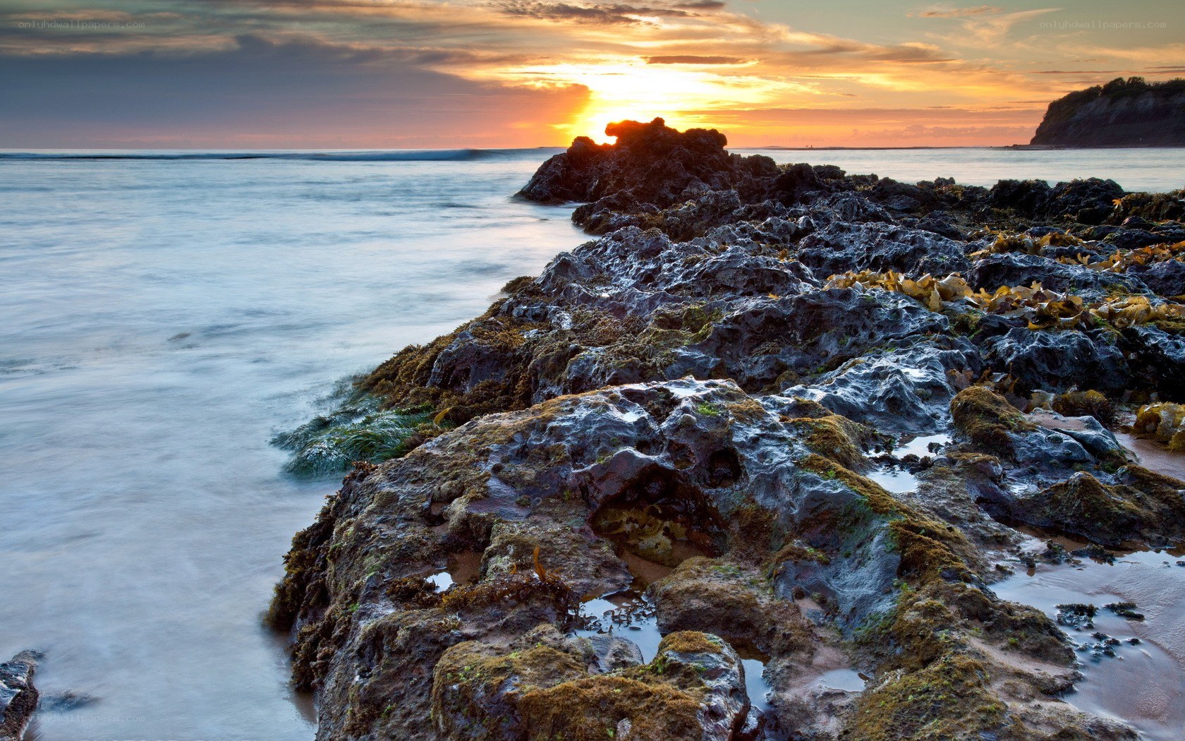 Sunset over rocky coastline