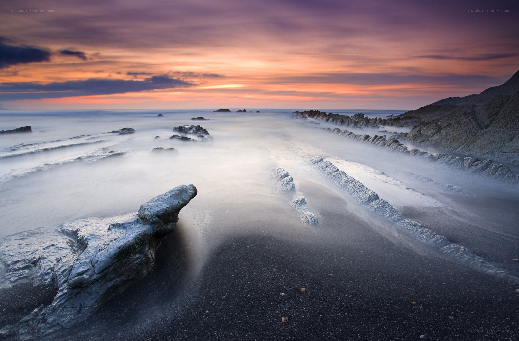 Sunset over rocky coastline