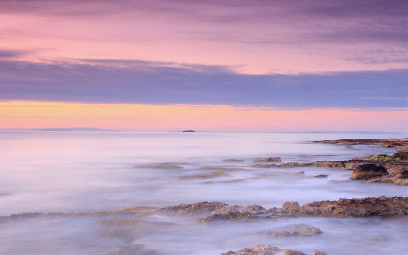 Sunset over rocky coastline