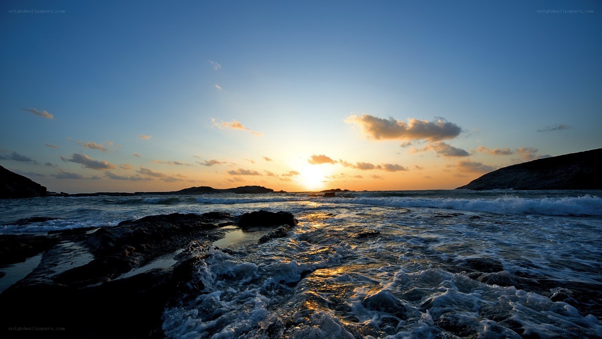 sunset over rocky coastline