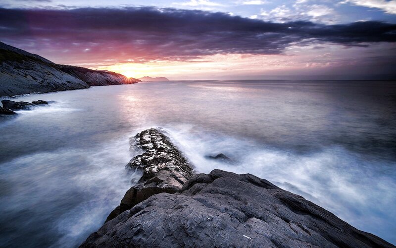 Sunset over rocky coastline