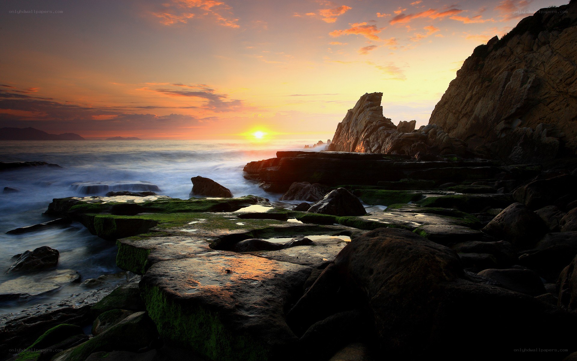 Sunset over rocky coastline