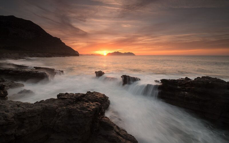 Sunset over rocky coastline