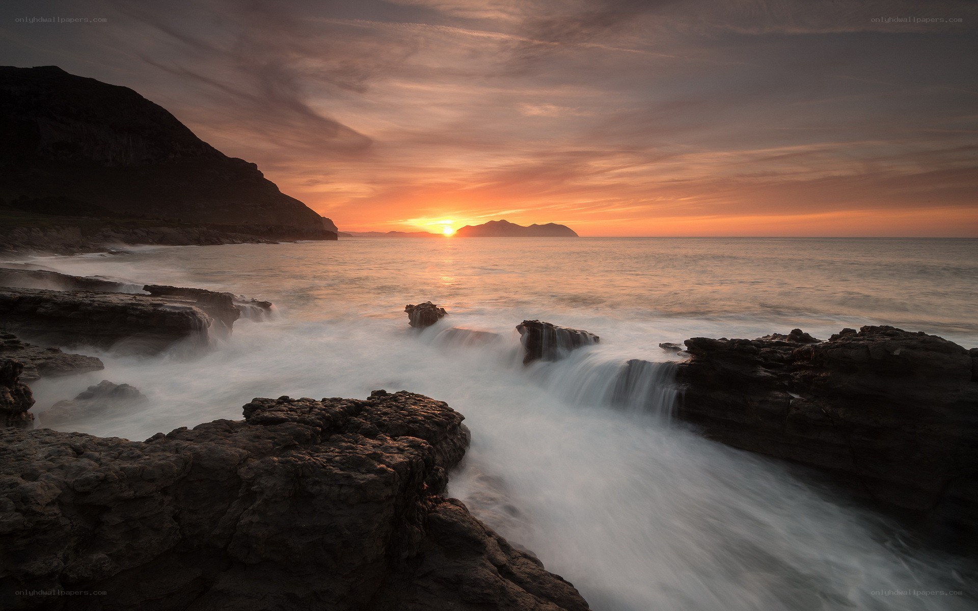 Sunset over rocky coastline