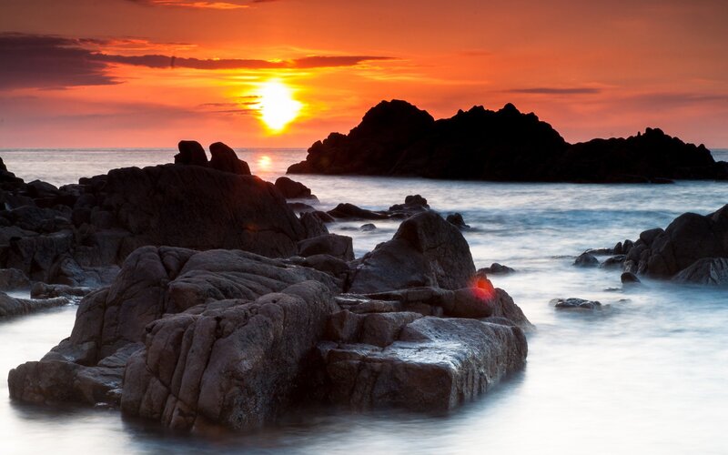 Sunset over rocky coastline