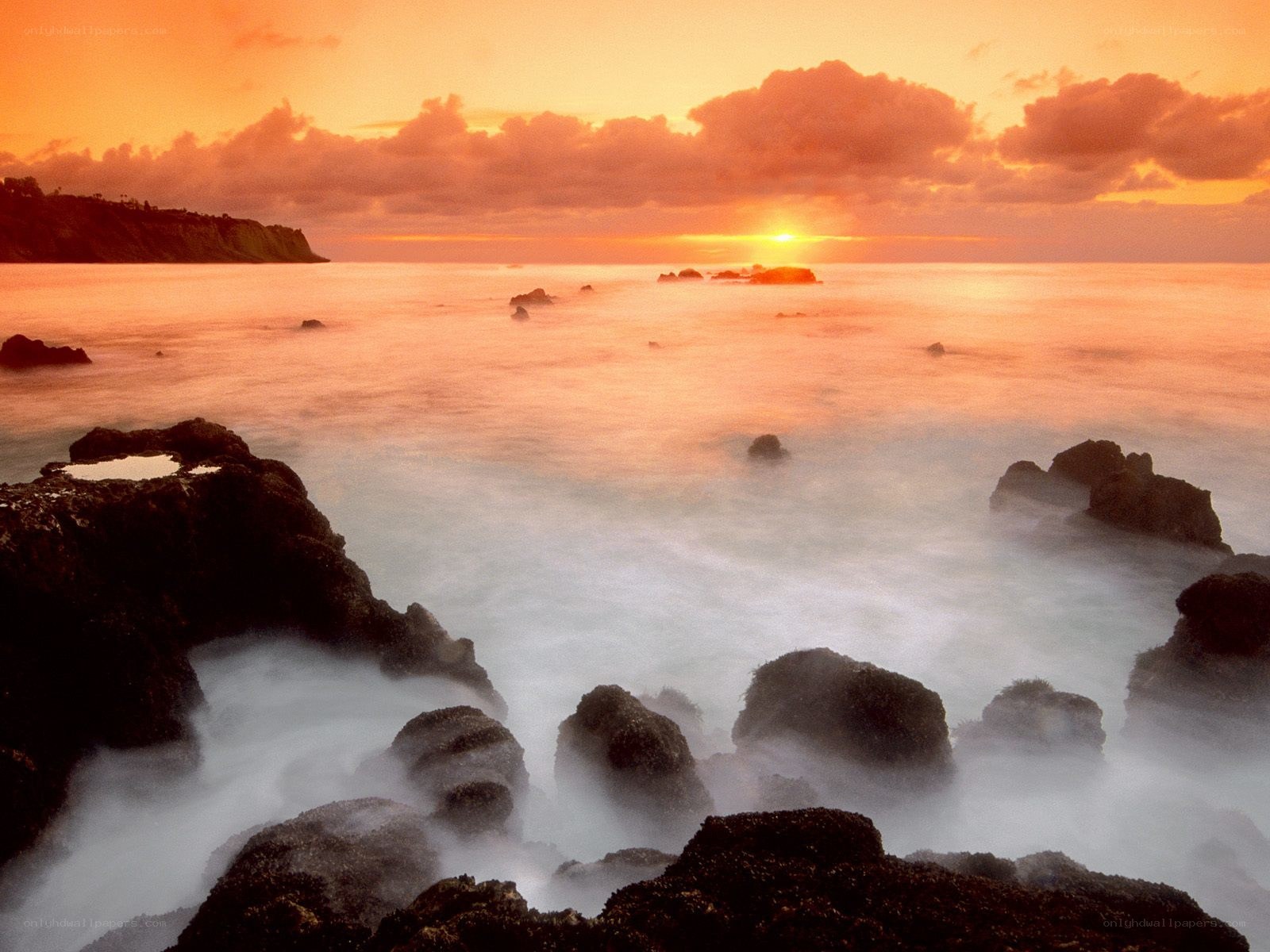sunset over rocky coastline