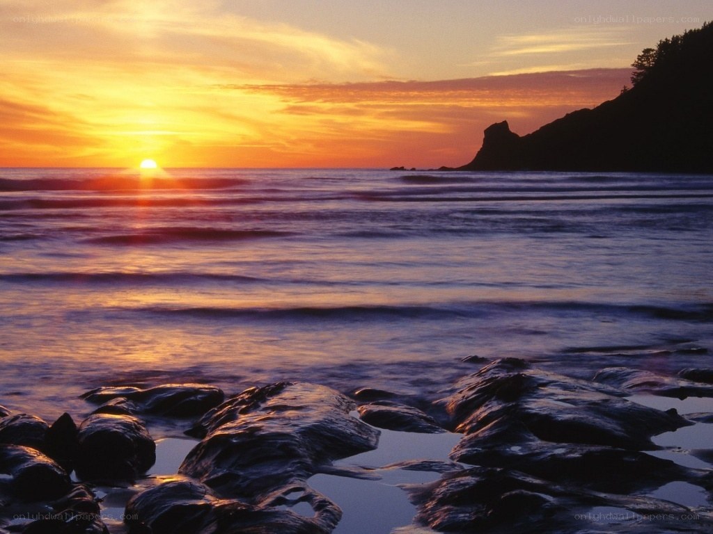 sunset over rocky coastline