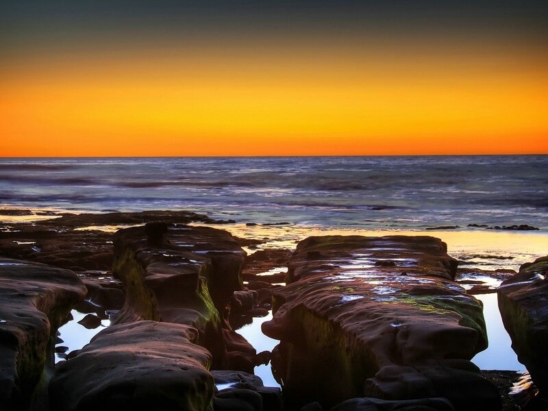 sunset over rocky coastline