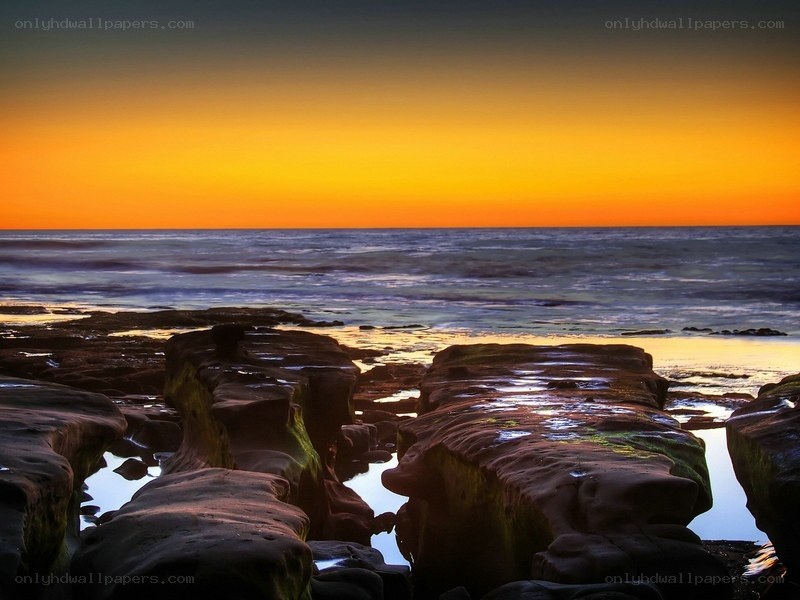 sunset over rocky coastline