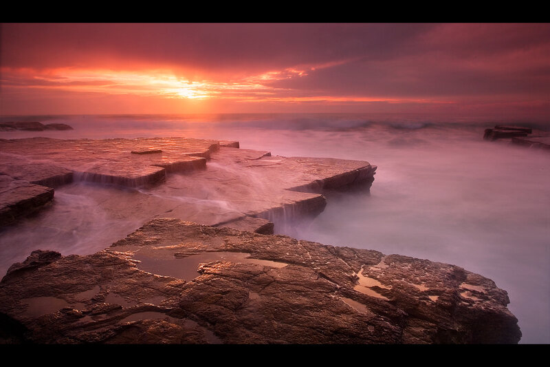 Sunset over rocky coastline