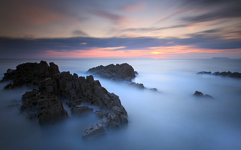 Sunset over rocky coastline
