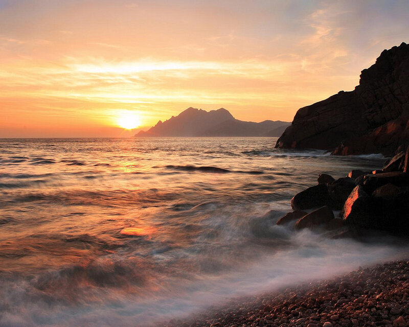 Sunset over rocky coastline