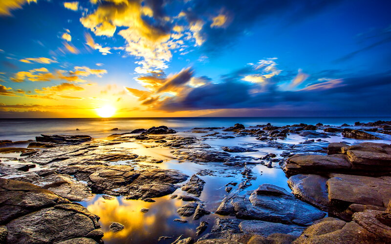 Sunset over Rocky Shore — Blue, Dramatic, Photograph, Sun, Clouds, Ocean, Rocks