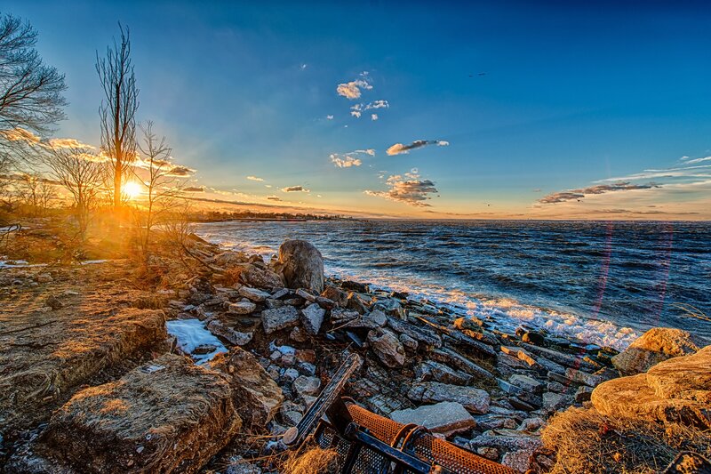 Sunset over Rocky Shore — Blue, Dramatic, Photograph, Sun, Rocks, Trees, Water