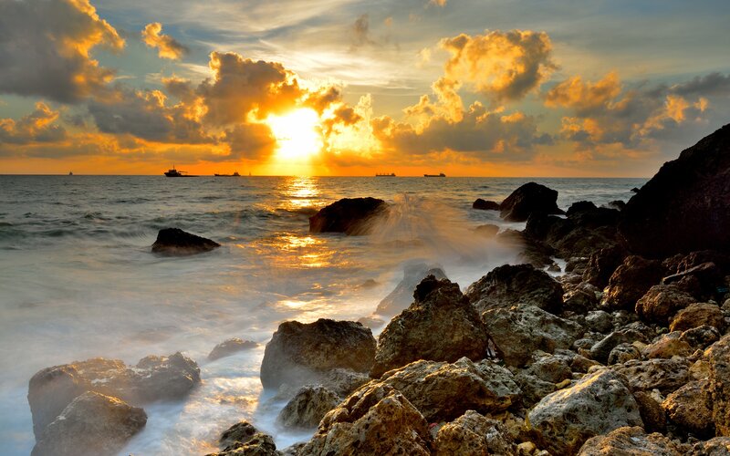 Sunset over Rocky Shore — Orange, Dramatic, Photograph, Ocean, Clouds, Ships