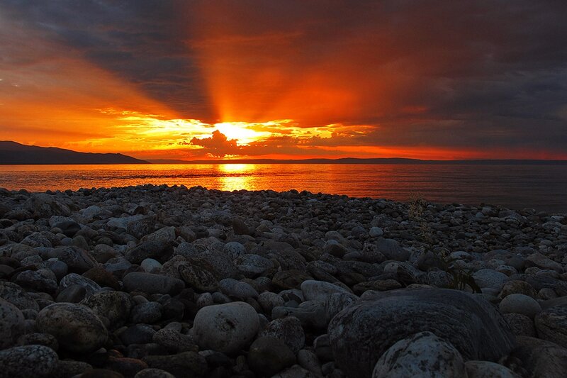 Sunset over Rocky Shore — Orange, Dramatic, Photograph, Rocks, Water, Mountains