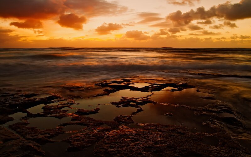 Sunset over rocky shoreline