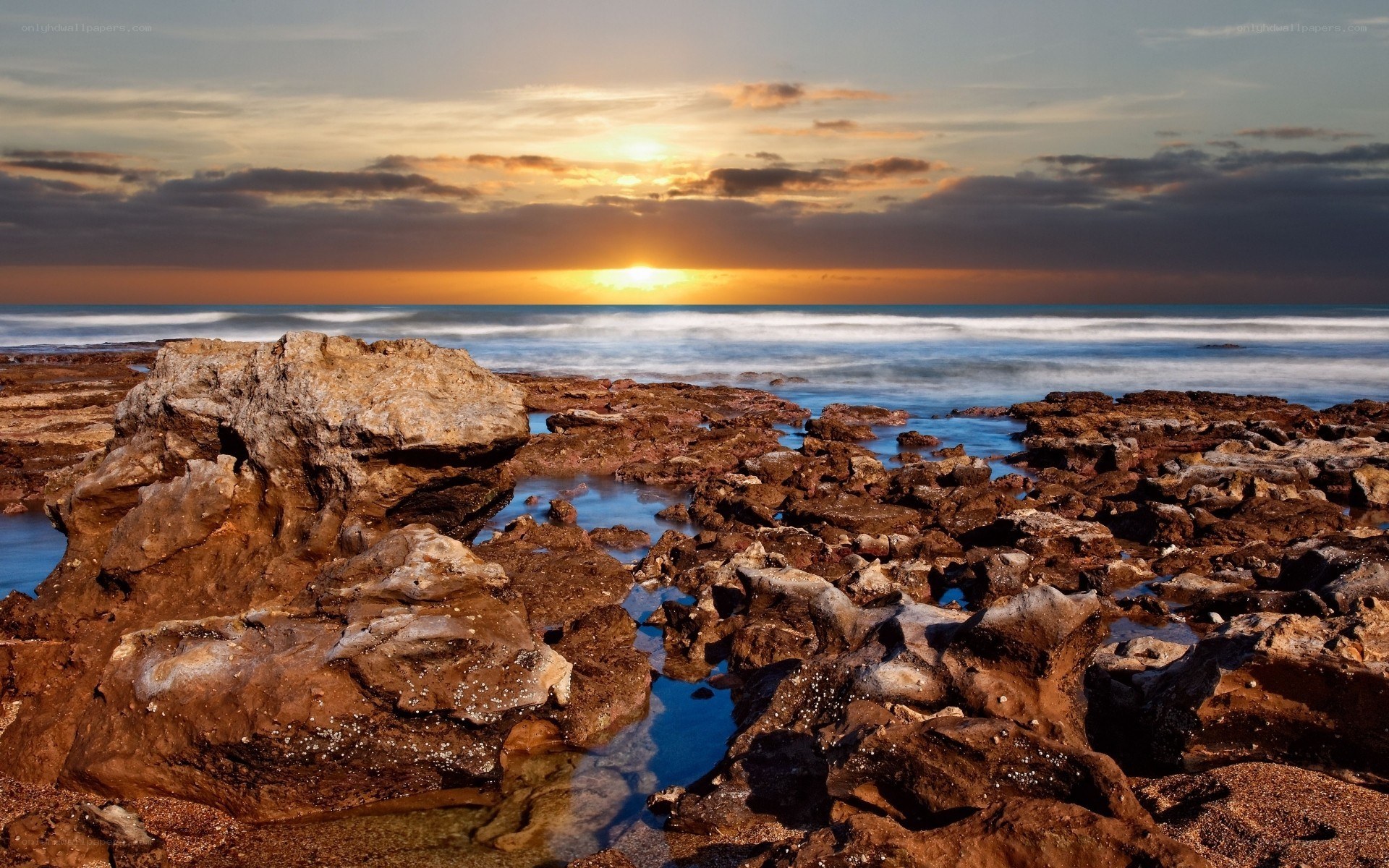 Sunset over rocky shoreline