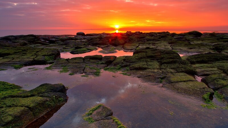 Sunset over rocky shoreline