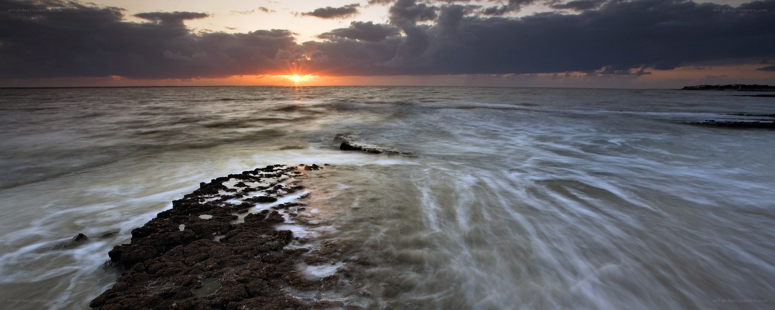 Sunset over rocky shoreline