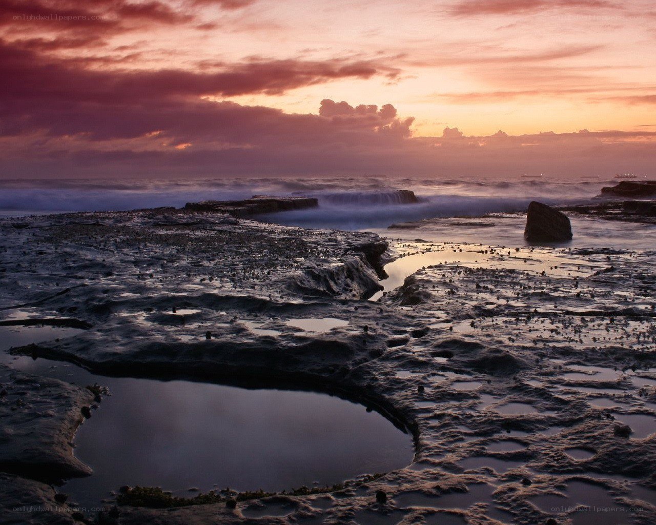 sunset over rocky shoreline