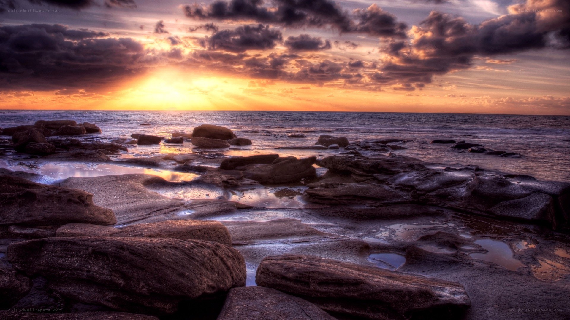 sunset over rocky shoreline