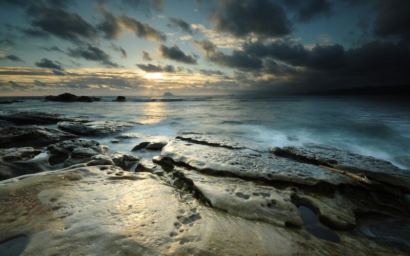 Sunset over rocky shoreline