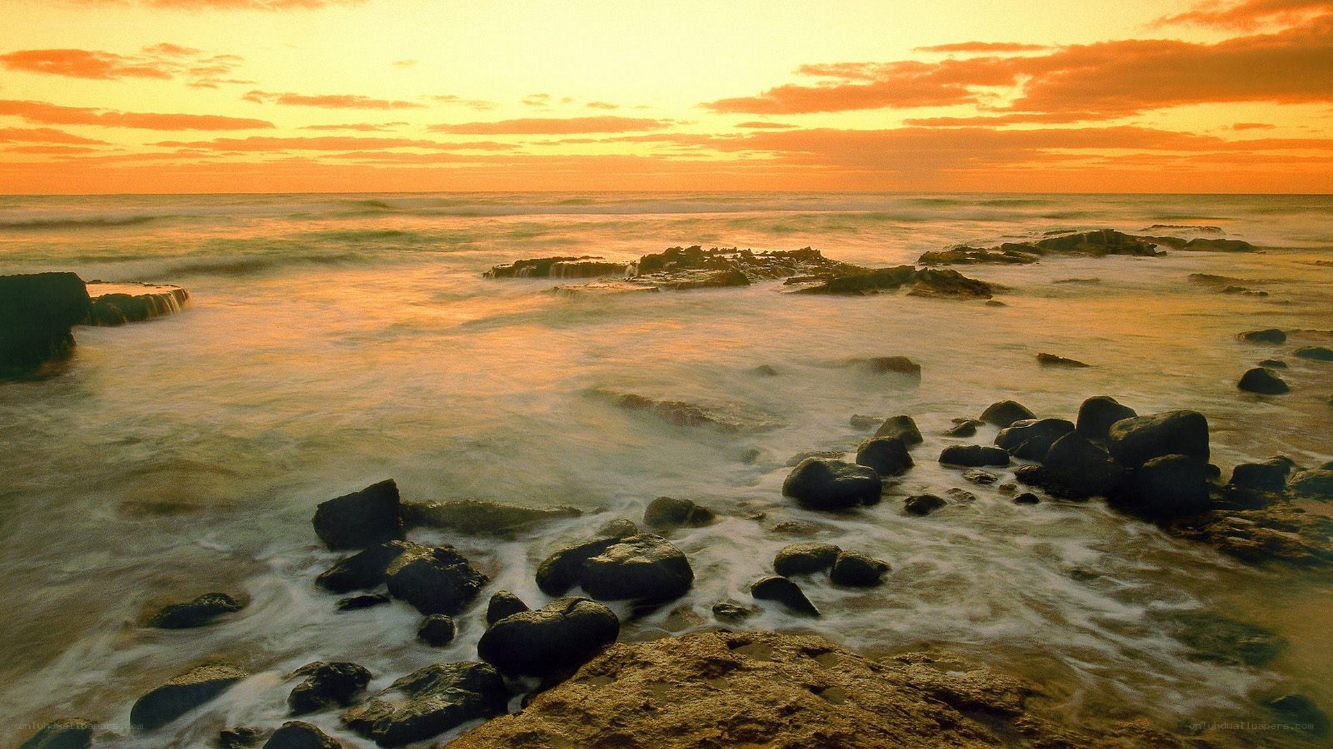 sunset over rocky shoreline