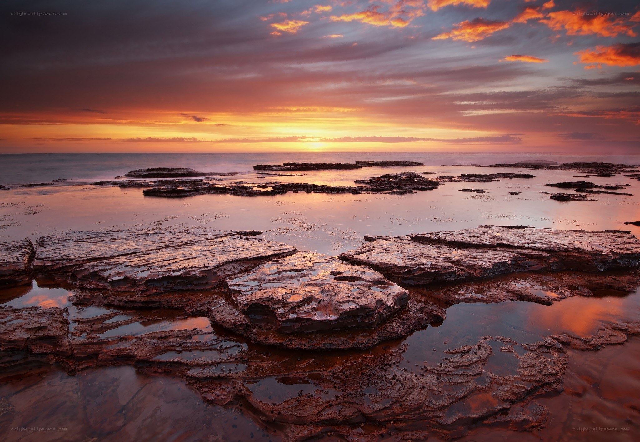 Sunset over rocky shoreline