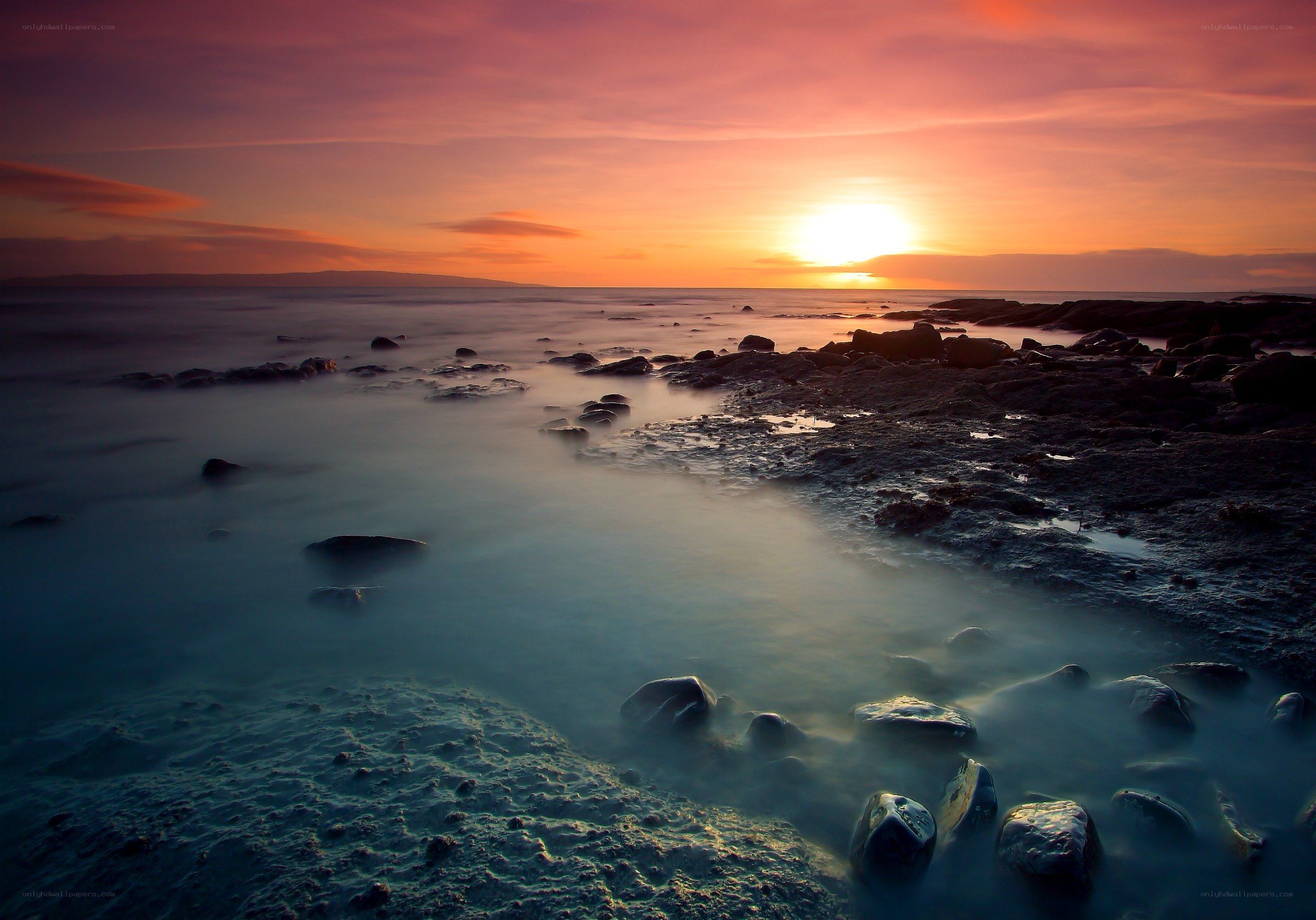 Sunset over rocky shoreline