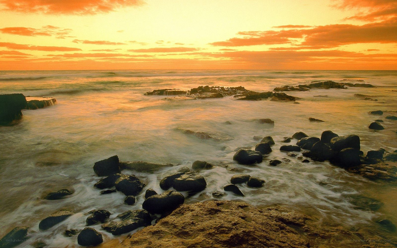 Sunset over rocky shoreline