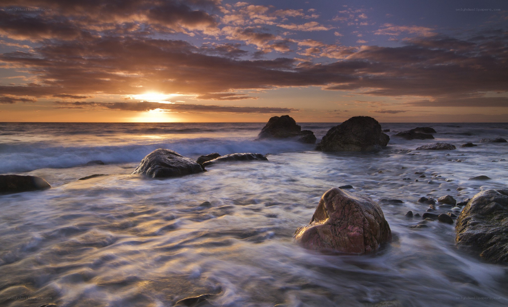 Sunset over rocky shoreline