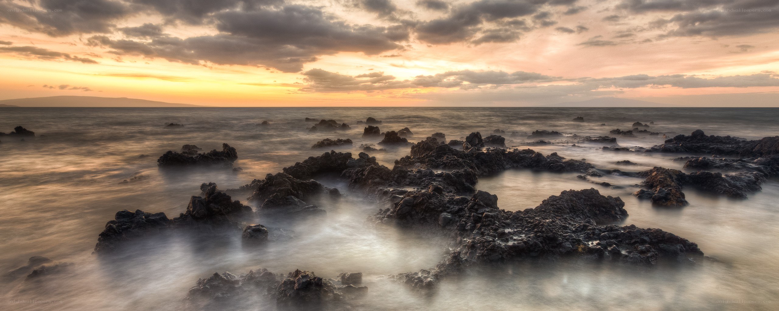 Sunset over rocky shoreline