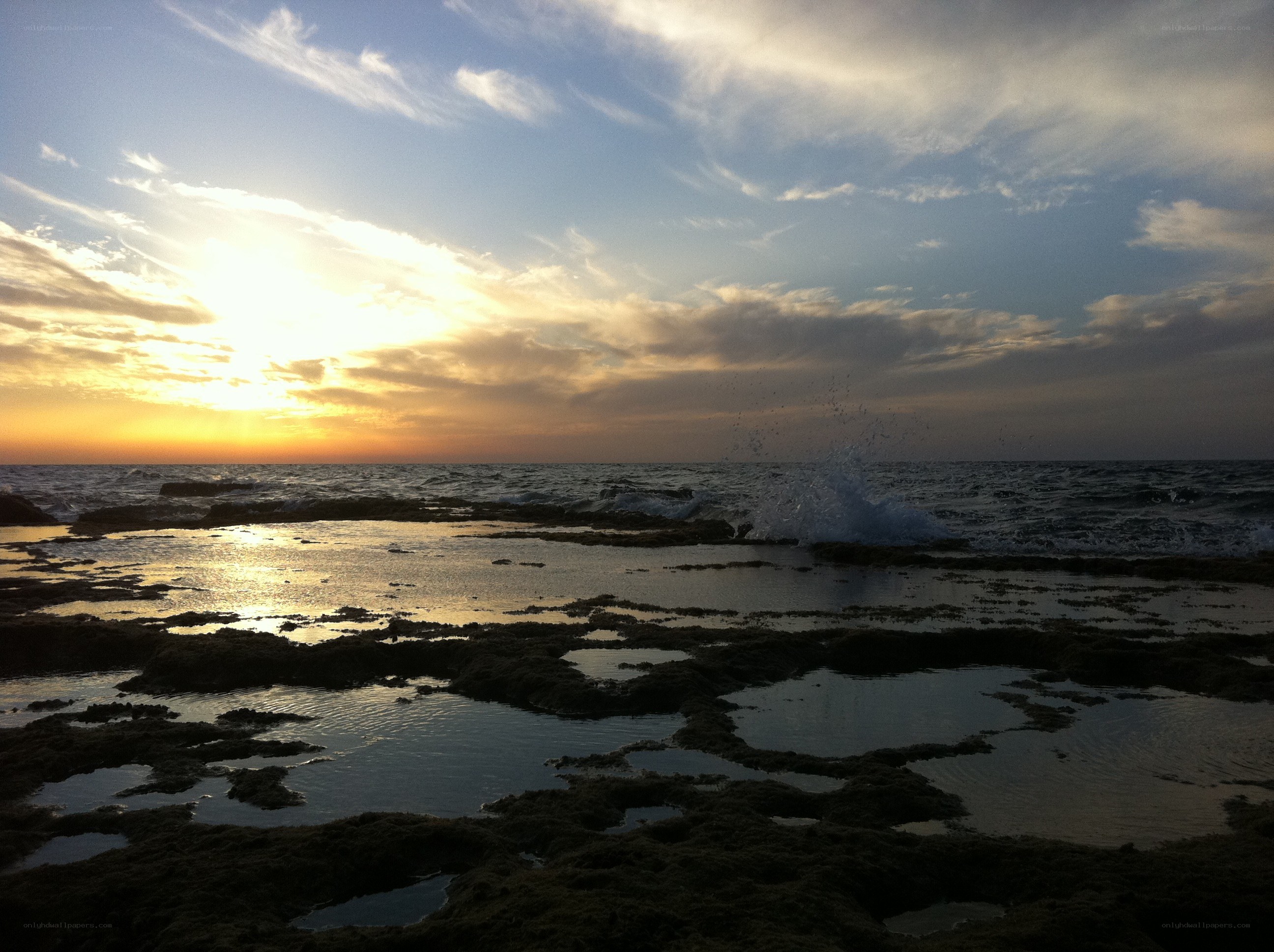 Sunset over rocky shoreline
