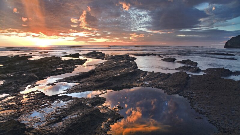 sunset over rocky shoreline