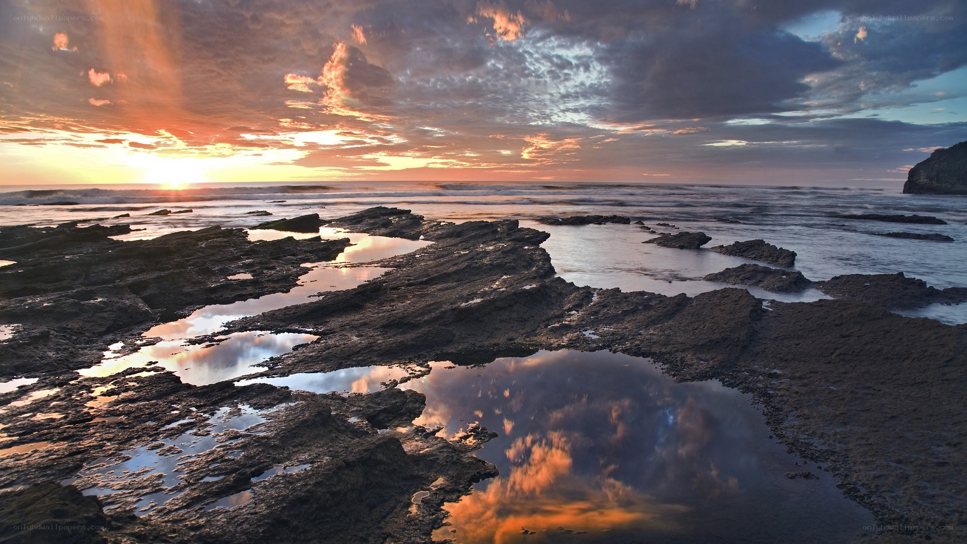 sunset over rocky shoreline
