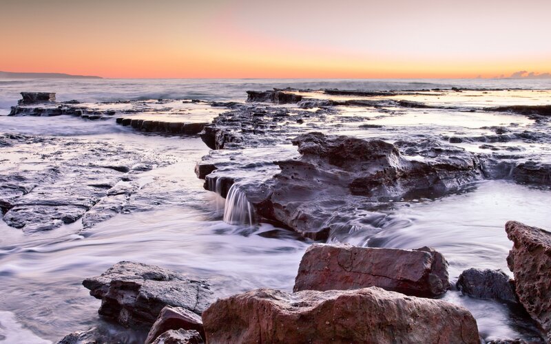 Sunset over rocky shoreline