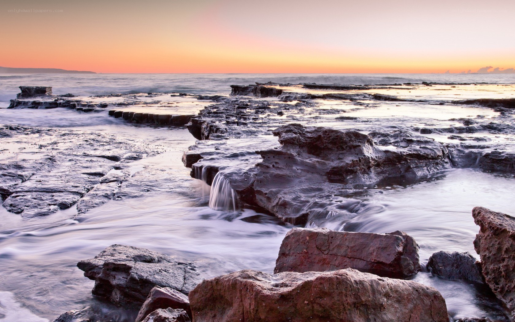 Sunset over rocky shoreline