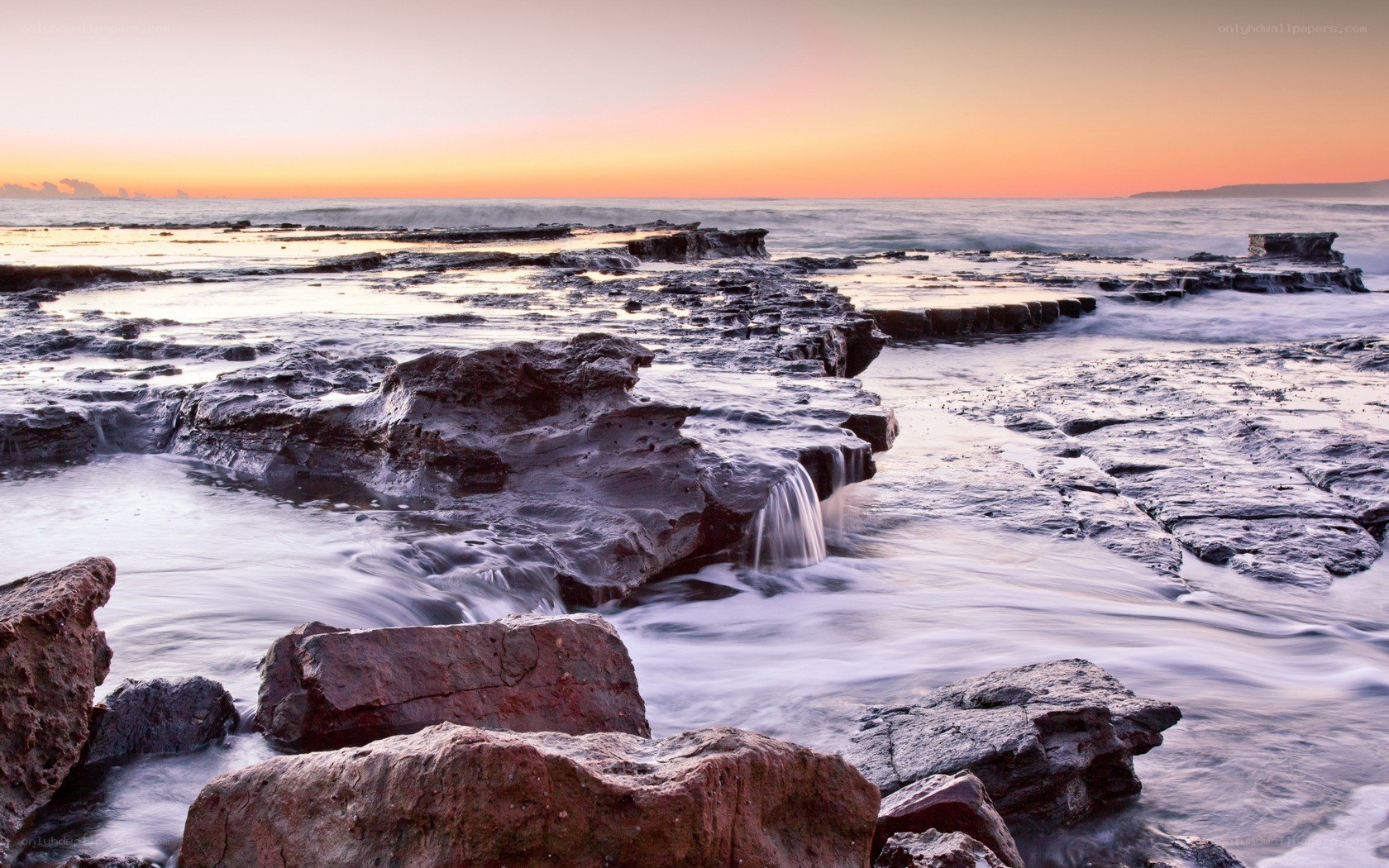 Sunset over rocky shoreline