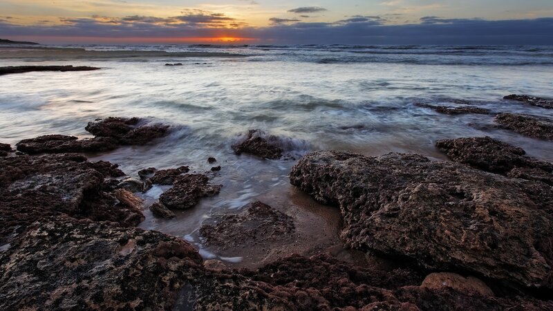 Sunset over rocky shoreline