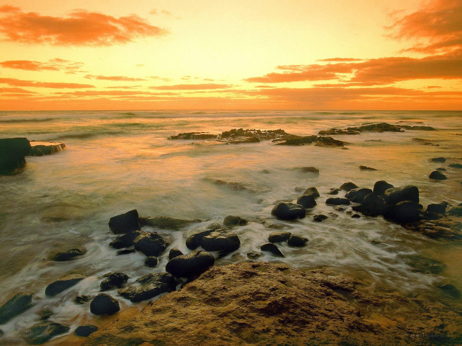 sunset over rocky shoreline