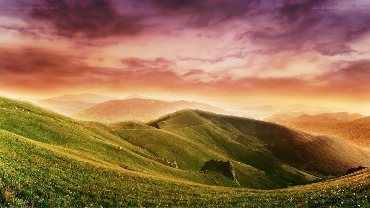 Sunset over rolling green hills