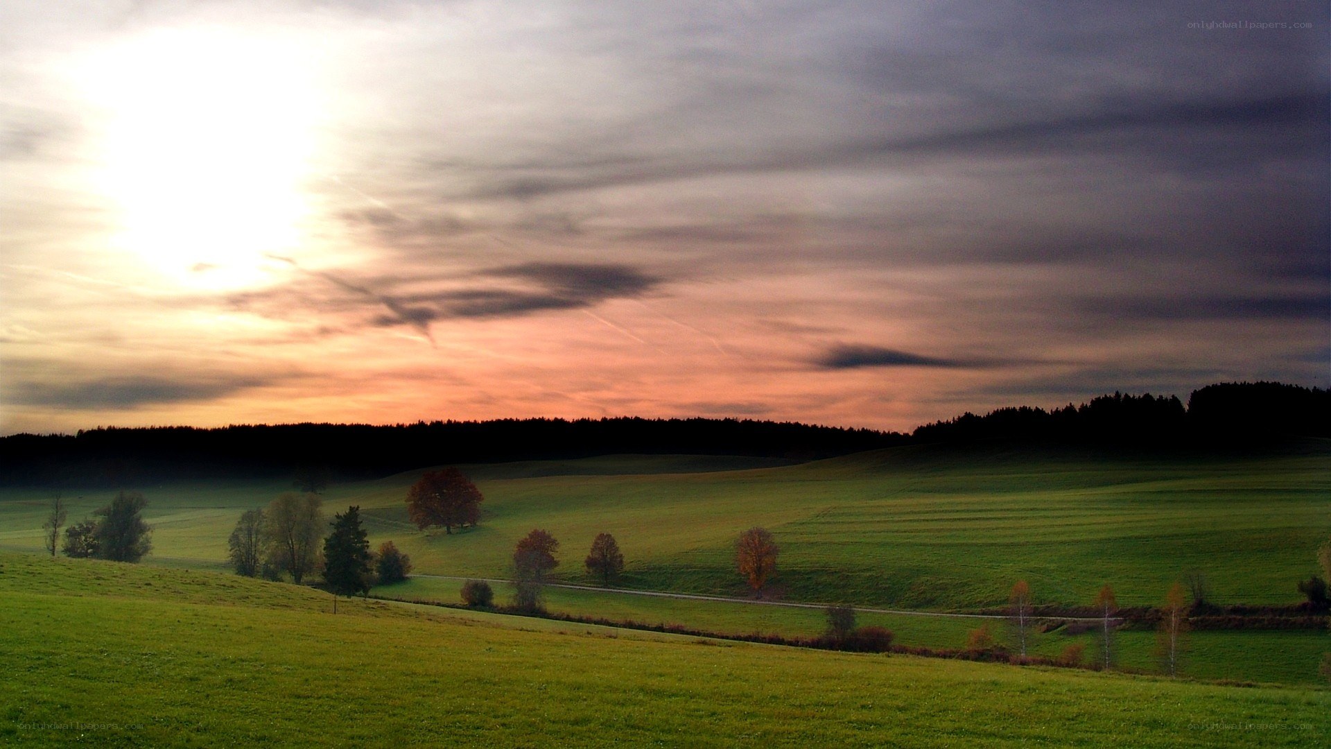 Sunset over rolling green hills